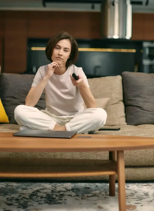 Person using a television remote in a modern living room